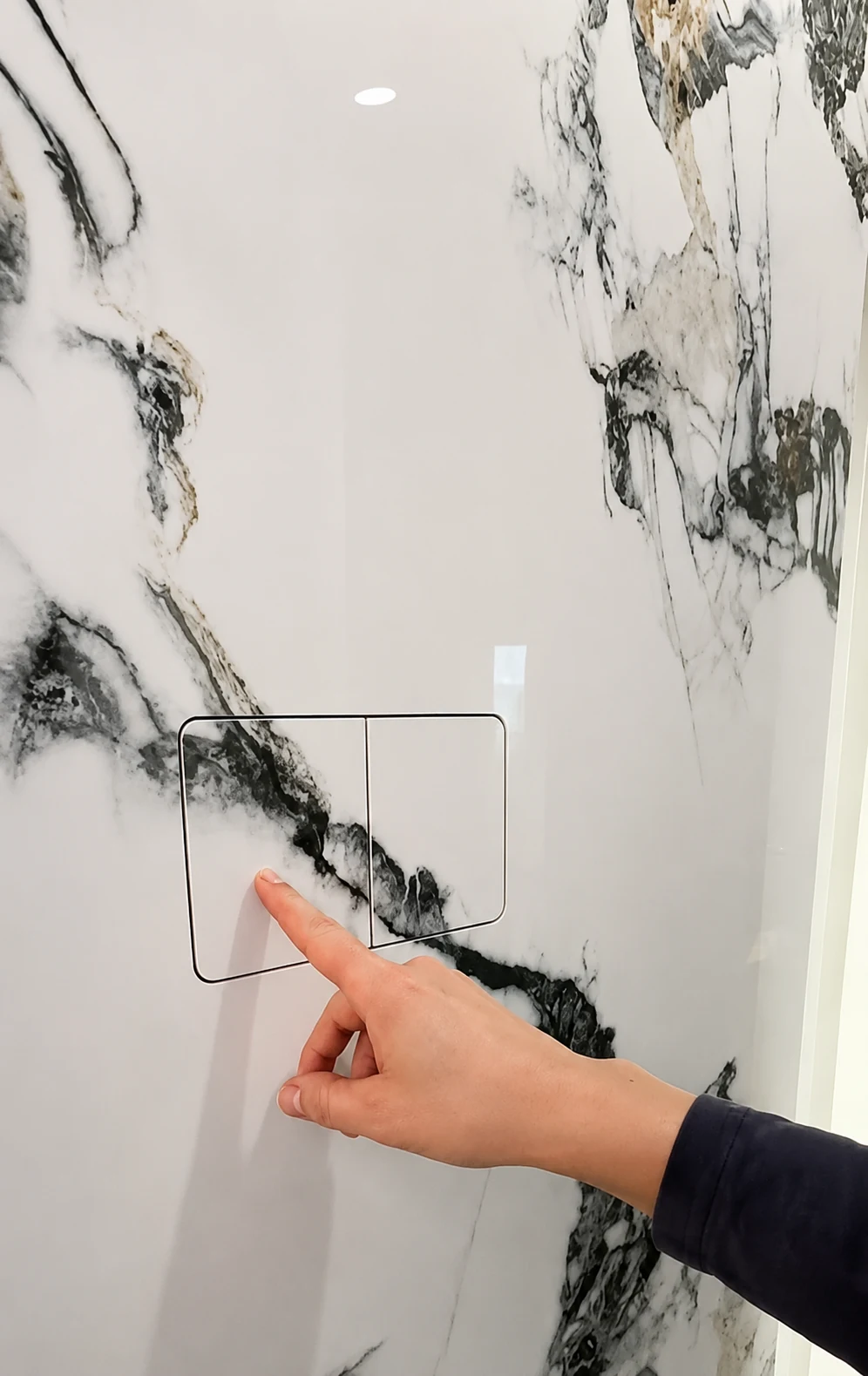 Frameless hidden flush button installed in marble tile